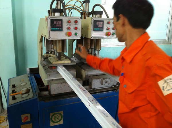 Công nhân sử dụng máy hàn khung cửa nhựa